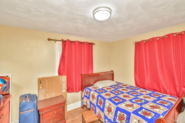 bedroom featuring wood finished floors and baseboards