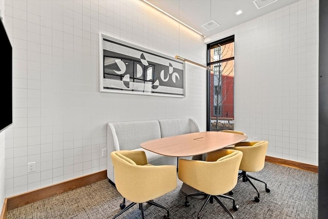 dining space with tile walls