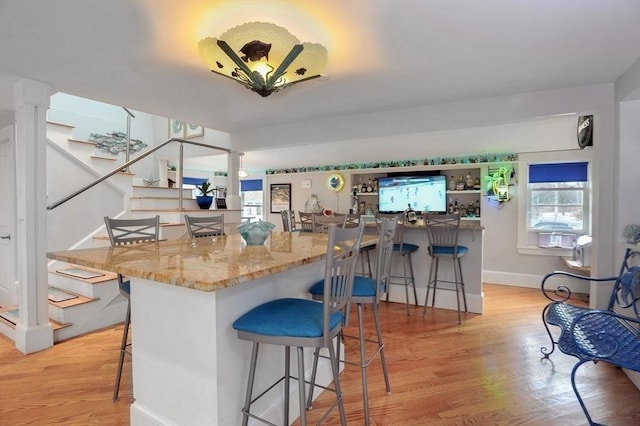 14 Lewis St, Hull, MA 02045 - kitchen with light wood-style floors, a breakfast bar area, stone counters, and baseboards