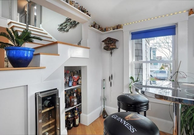 14 Lewis St, Hull, MA 02045 - living area featuring beverage cooler, a bar, wood finished floors, stairway, and baseboards