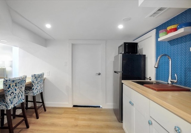 14 Lewis St, Hull, MA 02045 - kitchen with freestanding refrigerator, light wood-style floors, white cabinets, a sink, and recessed lighting