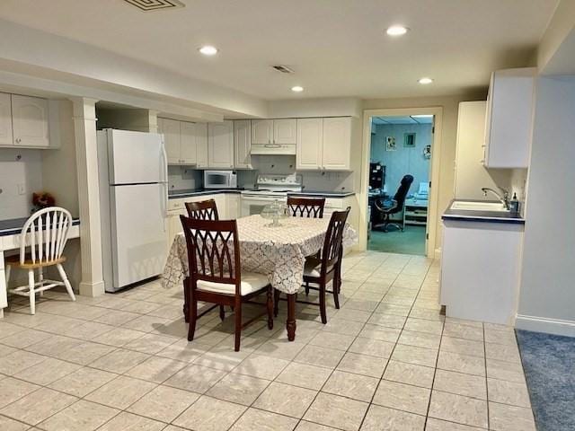dining area featuring baseboards, recessed lighting, and light tile patterned flooring