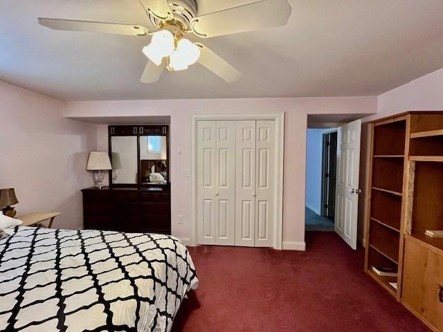 bedroom with carpet floors, a ceiling fan, and multiple closets