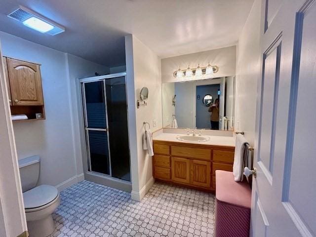 bathroom featuring vanity, toilet, baseboards, and a stall shower