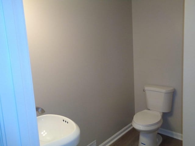 bathroom with hardwood / wood-style floors and toilet