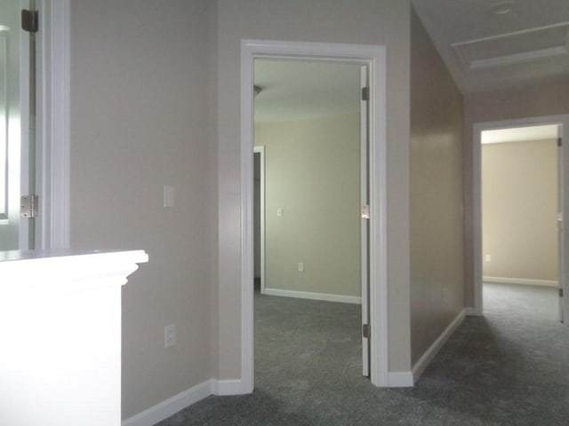 hall with dark colored carpet