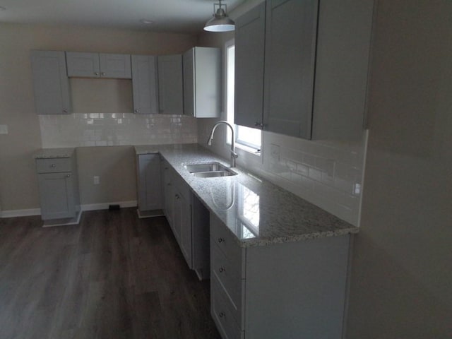 kitchen featuring pendant lighting, sink, dark hardwood / wood-style flooring, and gray cabinetry