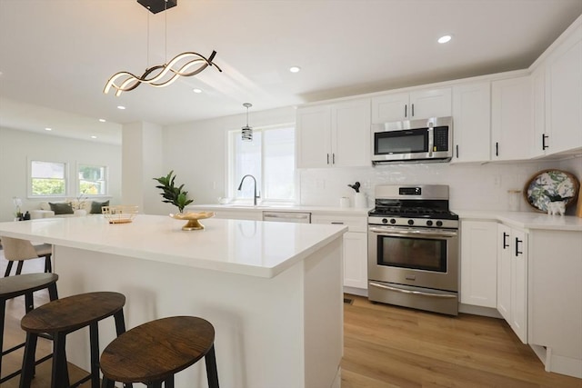 28 Custer St, Rockland, MA 02370 - kitchen with stainless steel appliances, a breakfast bar, recessed lighting, decorative backsplash, and a kitchen island