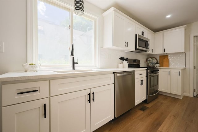 28 Custer St, Rockland, MA 02370 - kitchen featuring stainless steel appliances, a sink, decorative backsplash, white cabinets, and dark wood-style flooring