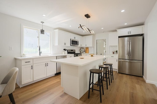 28 Custer St, Rockland, MA 02370 - kitchen featuring stainless steel appliances, white cabinets, a kitchen bar, light wood-type flooring, and recessed lighting