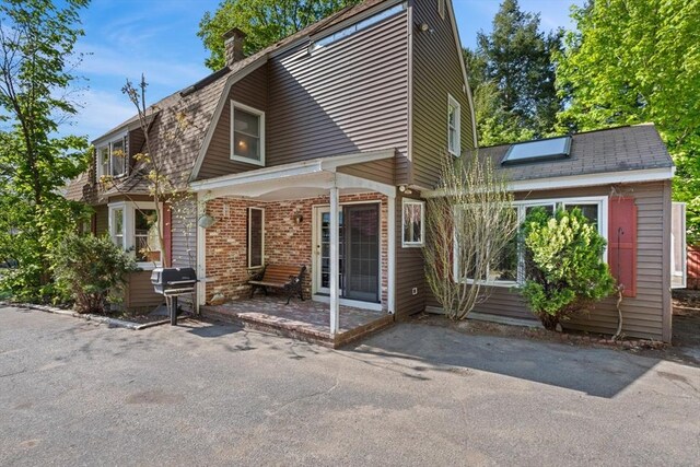 676 Salem St, Groveland, MA 01834 - rear view of property with a chimney, a porch, and brick siding