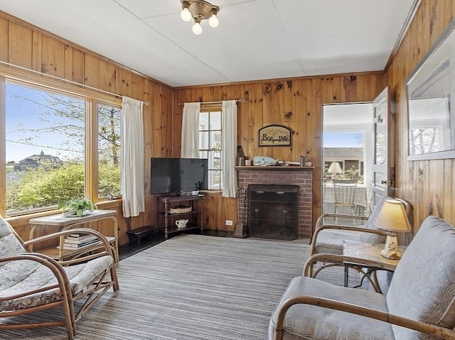 living area featuring wood walls and a brick fireplace