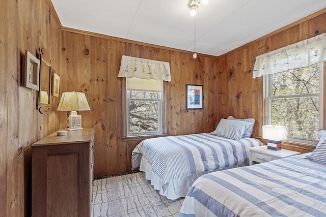 bedroom with multiple windows and wood walls