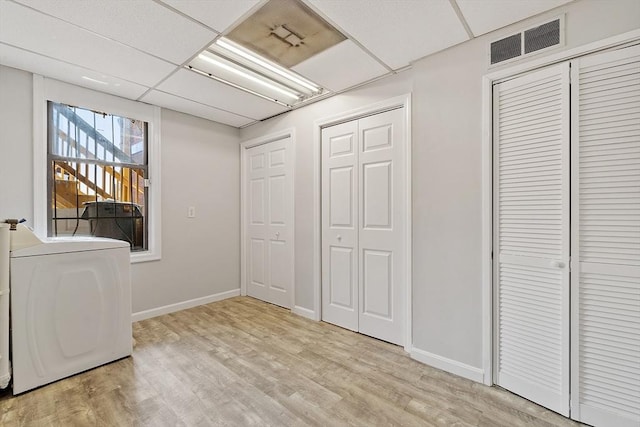 104 Pleasant St, Worcester, MA 01609 - unfurnished bedroom featuring washer / dryer, multiple closets, light wood finished floors, and a drop ceiling