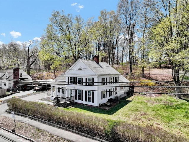 view of property exterior featuring a yard, fence, and a chimney