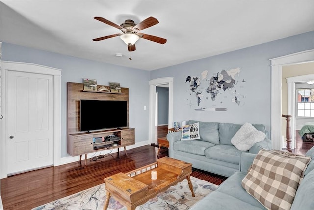 living room with baseboards, ceiling fan, and wood finished floors
