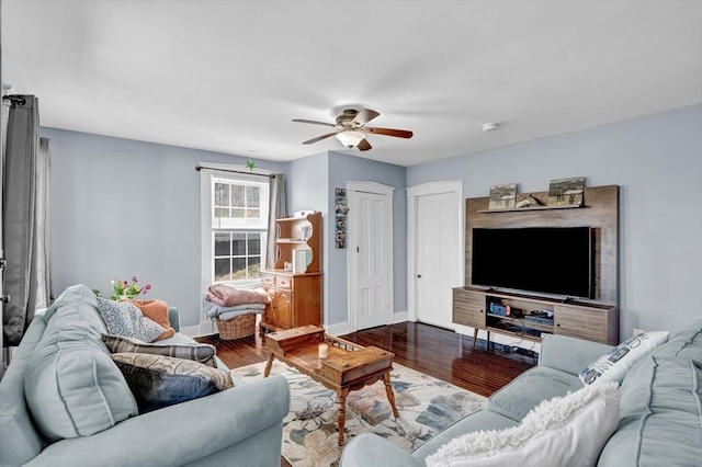 living room with baseboards, a ceiling fan, and wood finished floors