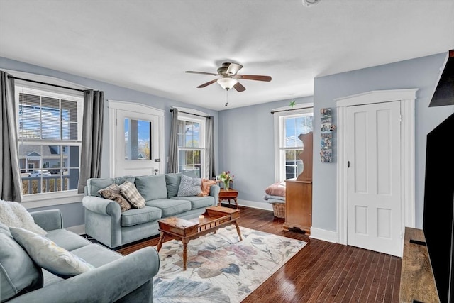 living area with baseboards, dark wood finished floors, and ceiling fan