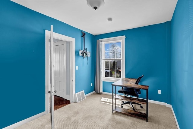 carpeted home office with visible vents and baseboards