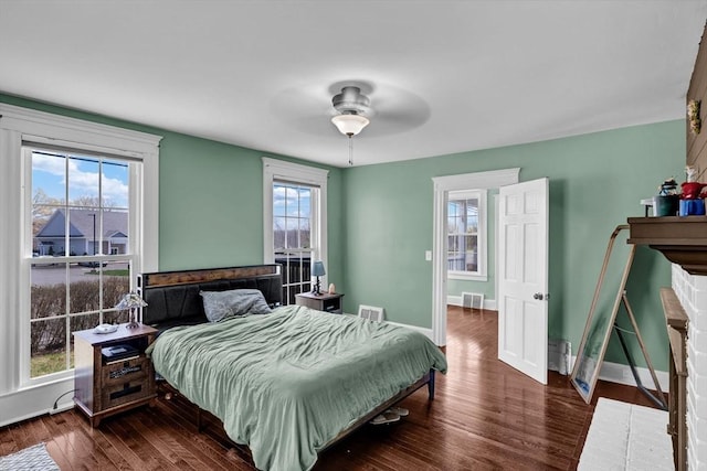 bedroom featuring ceiling fan, visible vents, baseboards, and dark wood-type flooring