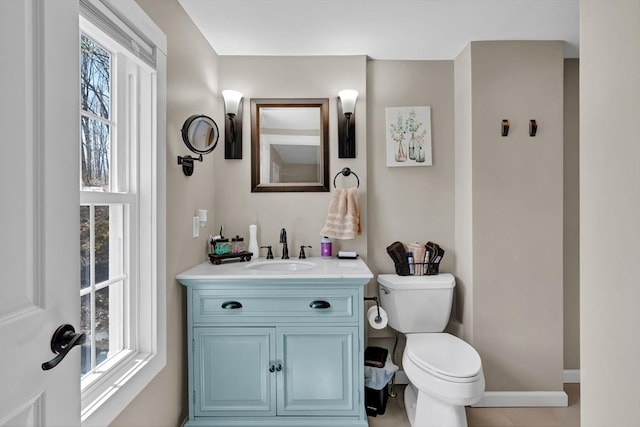 half bath featuring toilet, baseboards, and vanity