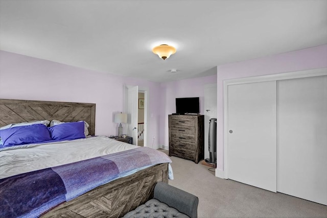 bedroom with light colored carpet and a closet
