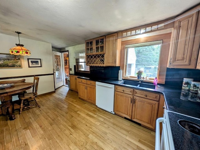 74 Ellis Rd, Southbridge, MA 01550 - kitchen with dishwasher, a sink, light wood-style flooring, dark countertops, and brown cabinetry