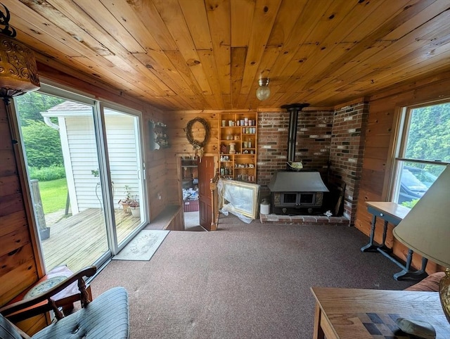 74 Ellis Rd, Southbridge, MA 01550 - living area with wooden ceiling, wooden walls, healthy amount of natural light, a wood stove, and carpet flooring