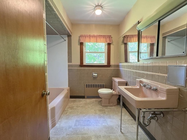 4 Norman Cir, Montague, MA 01376 - full bathroom with radiator heating unit, tile walls, toilet, shower / washtub combination, and a wainscoted wall