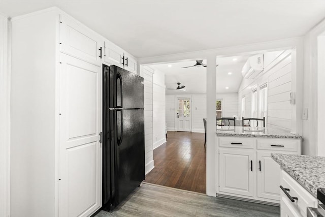 19 Arlington Rd, Dedham, MA 02026 - kitchen with freestanding refrigerator, wood finished floors, ceiling fan, an AC wall unit, and white cabinets