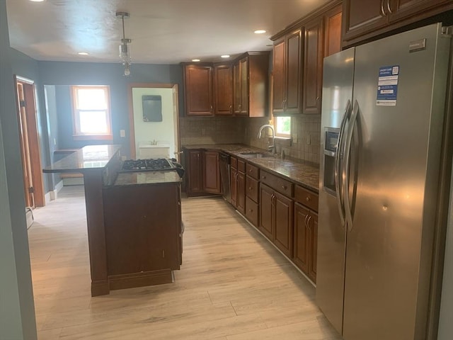 205 Gardner Rd, Hubbardston, MA 01452 - kitchen with appliances with stainless steel finishes, light wood-type flooring, dark stone counters, a kitchen island, and tasteful backsplash
