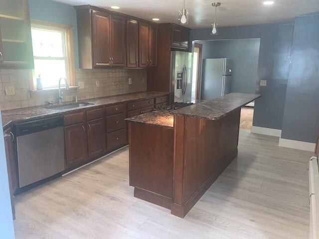 205 Gardner Rd, Hubbardston, MA 01452 - kitchen with appliances with stainless steel finishes, a center island, backsplash, light wood-style floors, and dark stone counters