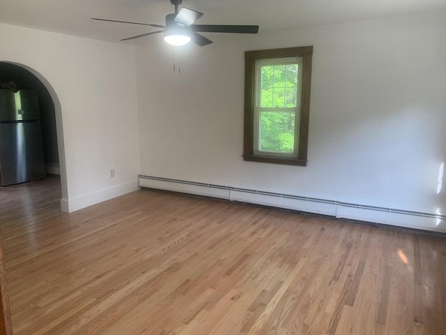 205 Gardner Rd, Hubbardston, MA 01452 - spare room featuring a baseboard radiator, light wood-style flooring, a ceiling fan, and arched walkways