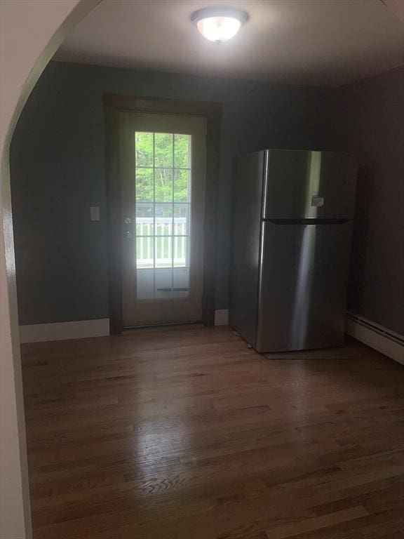 205 Gardner Rd, Hubbardston, MA 01452 - kitchen featuring freestanding refrigerator, arched walkways, light wood-style floors, and baseboard heating