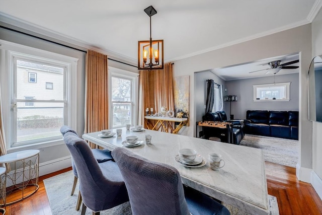 dining room featuring hardwood / wood-style floors, crown molding, and ceiling fan with notable chandelier