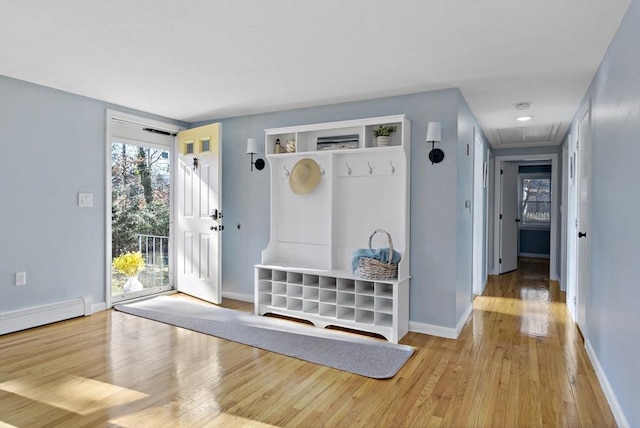 interior space with a baseboard heating unit and light hardwood / wood-style flooring