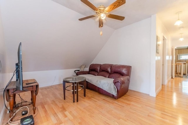 living area with vaulted ceiling, ceiling fan, and light wood-type flooring