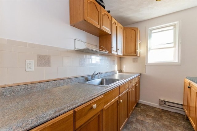 kitchen featuring a baseboard heating unit, sink, and backsplash