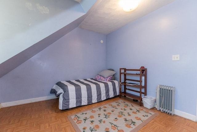 bedroom with light parquet floors and radiator