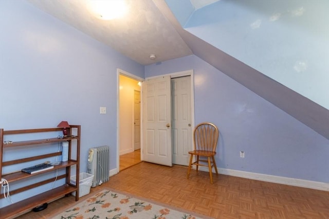 additional living space featuring light parquet floors, lofted ceiling, and radiator