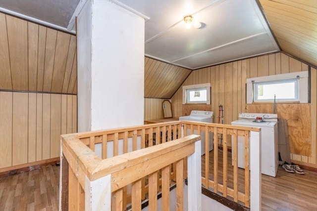 bonus room with light hardwood / wood-style flooring, washer / dryer, vaulted ceiling, and wood walls