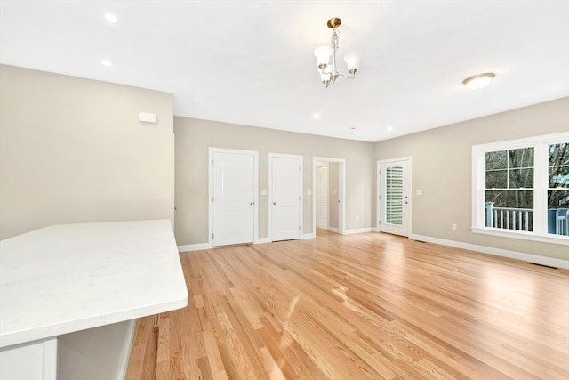 interior space with visible vents, baseboards, light wood-style floors, a notable chandelier, and recessed lighting