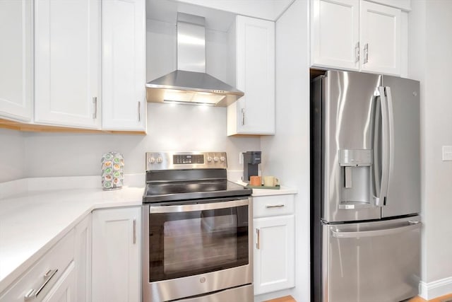 kitchen featuring appliances with stainless steel finishes, light countertops, white cabinets, and wall chimney exhaust hood