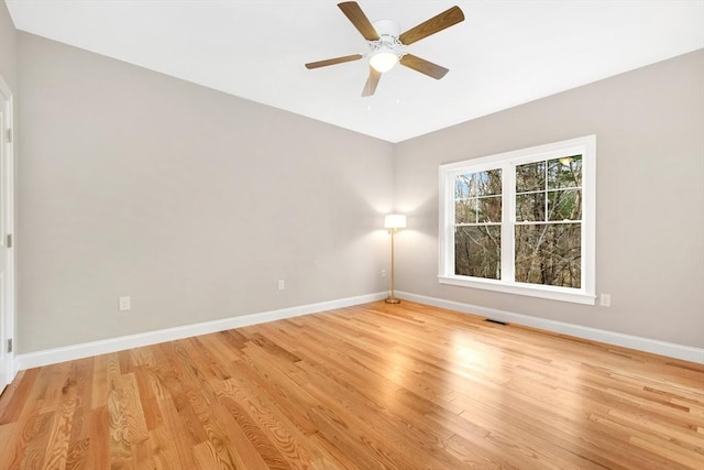 empty room featuring light wood finished floors, visible vents, and baseboards