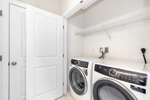 laundry area featuring laundry area, independent washer and dryer, and light tile patterned floors