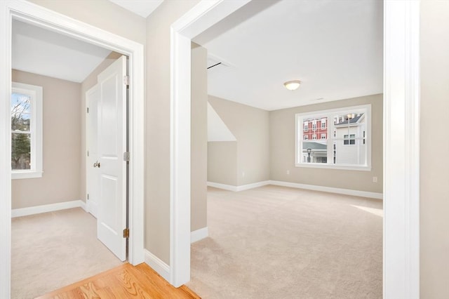 interior space with light carpet and baseboards