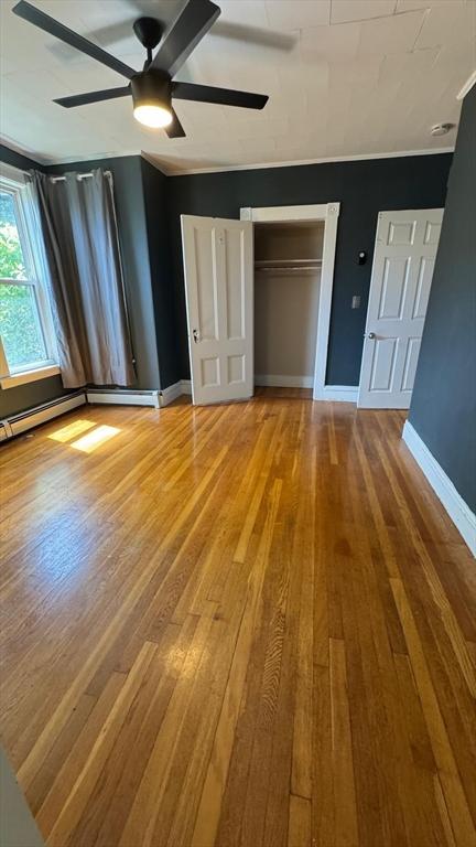486-488 E Merrimack St, Lowell, MA 01852 - unfurnished bedroom featuring wood finished floors, baseboards, a closet, and ceiling fan
