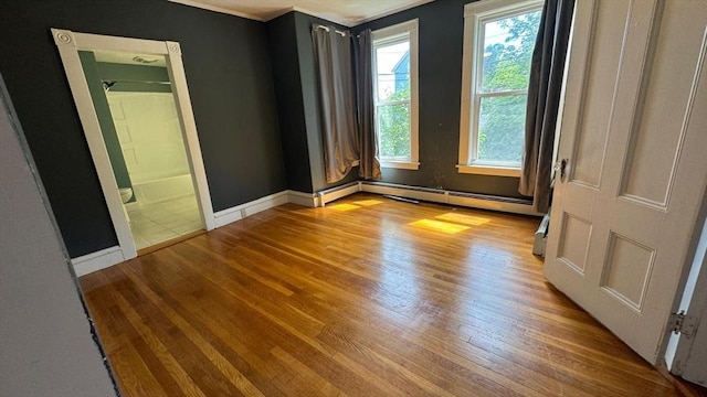 486-488 E Merrimack St, Lowell, MA 01852 - empty room featuring wood finished floors, crown molding, baseboards, and a baseboard radiator