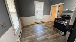 486-488 E Merrimack St, Lowell, MA 01852 - kitchen featuring stainless steel range with gas stovetop, baseboard heating, wood finished floors, plenty of natural light, and a wainscoted wall