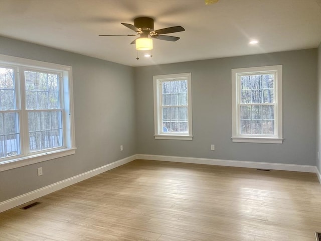 spare room featuring plenty of natural light, baseboards, and visible vents